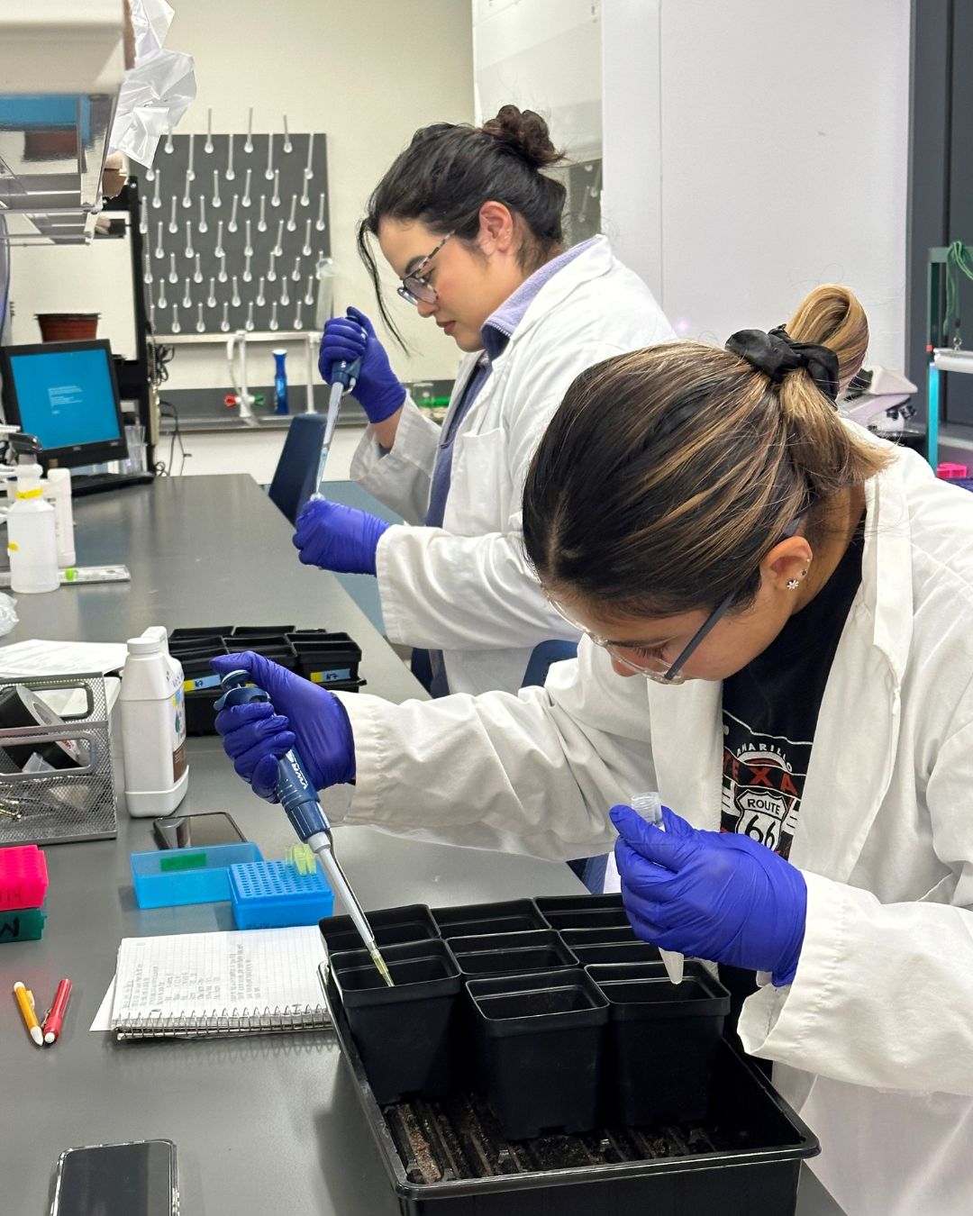 Two women in lab coats testing water samples