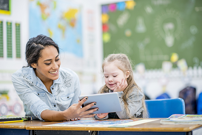 Special Educator in class engaging with student.