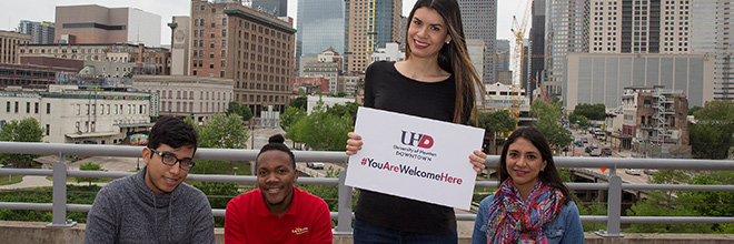 students posing in front of downtown skyline for the 'You Are Welcome Here' campaign