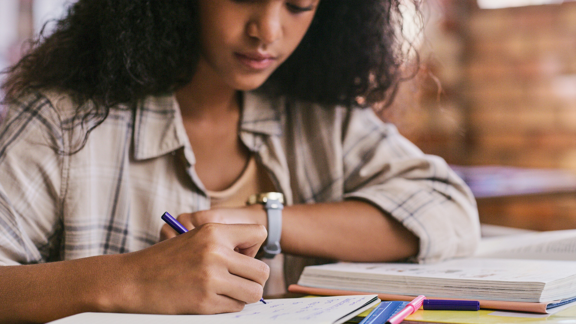 female college student writes on a pad 