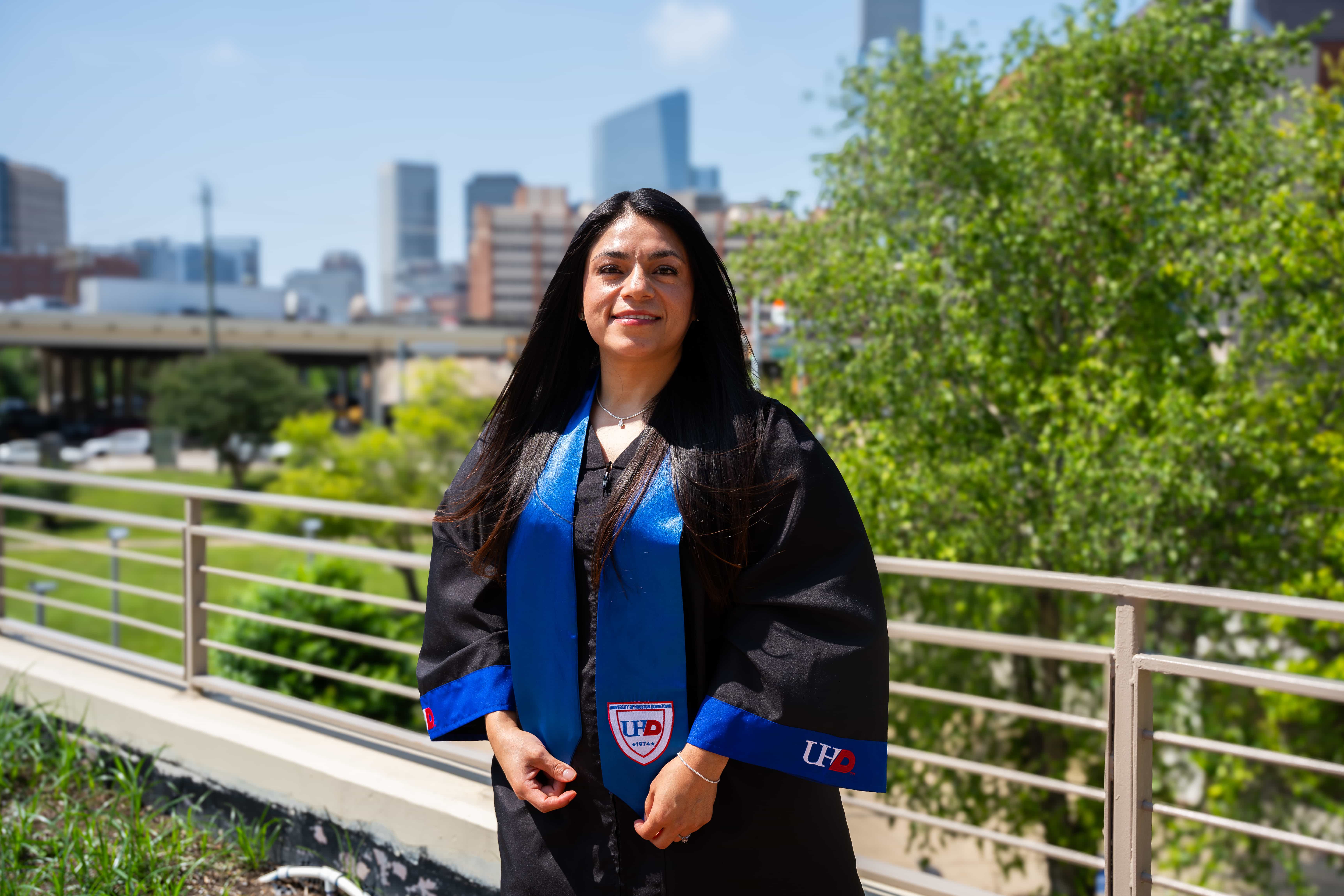 female student posing with a cityscape background