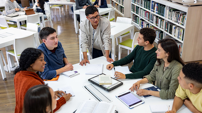 Group of teenagers debating around a table