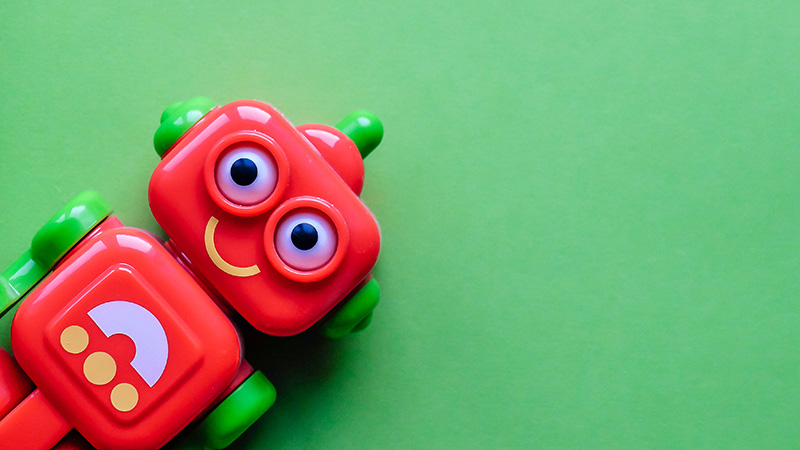 Red toy robot on a green background