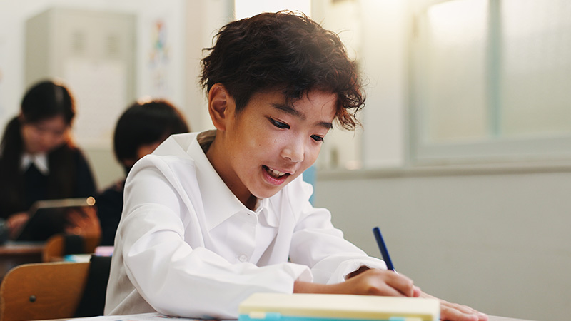 Young boy writing in a journal