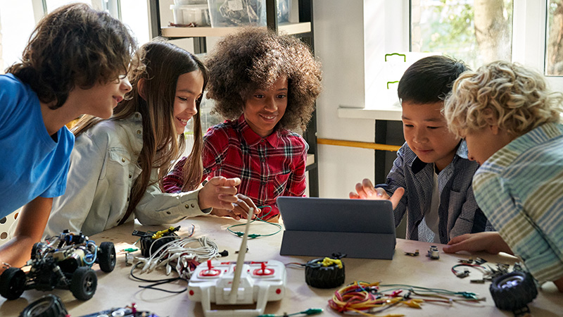 Group of students with robot parts on a table