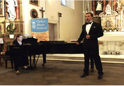 Photograph of male vocalist singing with woman at piano Orfeo Music Festival in Italy