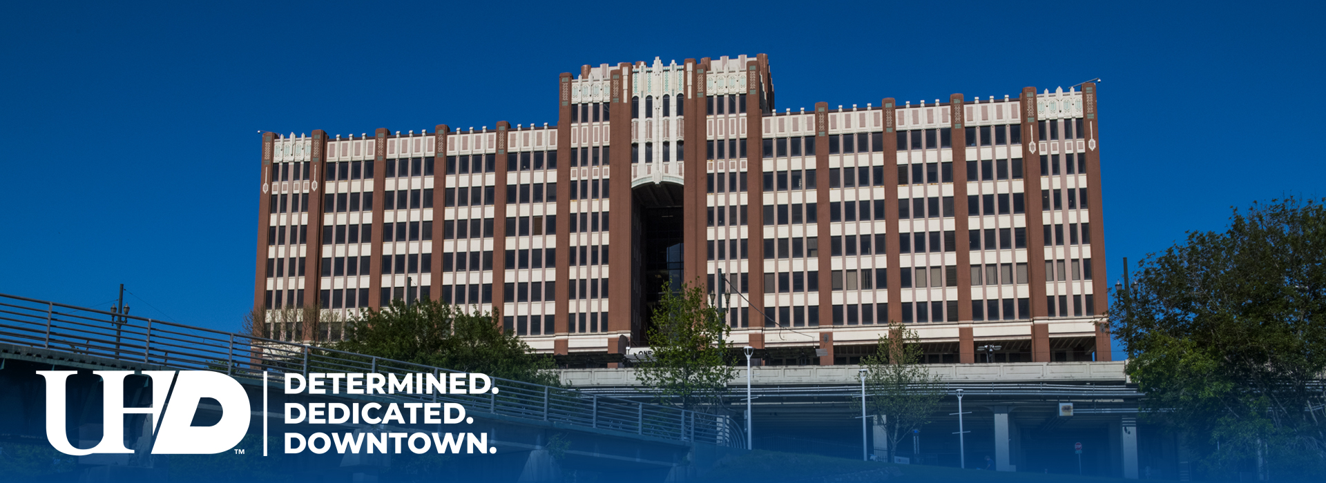 One Main Building of the University of Houston-Downtown with the Dertmined, Dedicated, Downtown logo.