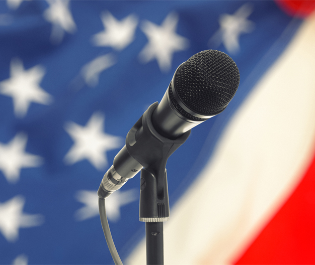 Microphone on a stand with the US flag in the background