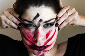 female face with smeared red and black makeup