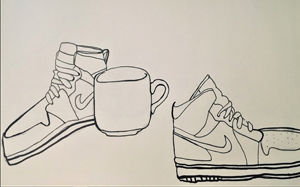 two Nike tennis shoes and a mug