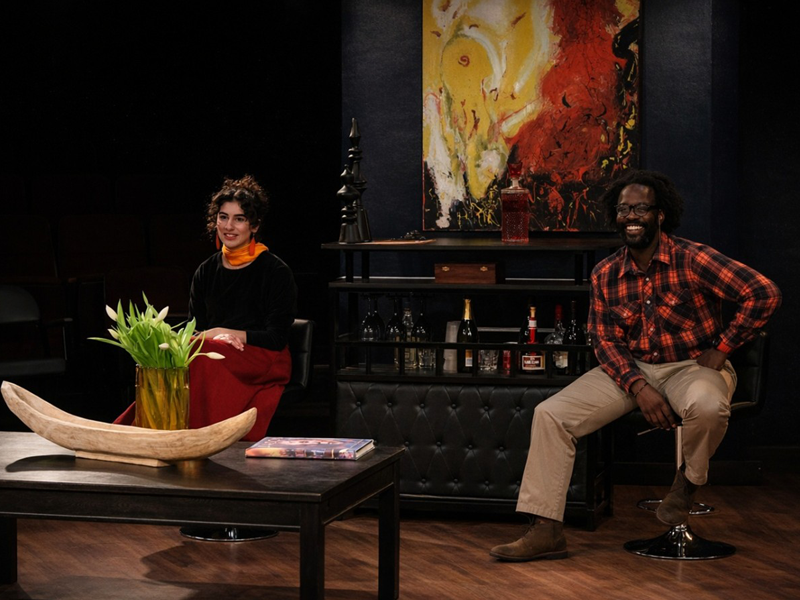 female and male actor seated on stage