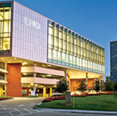 Exterior of the UHD Welcome Center building and downtown buildings at night