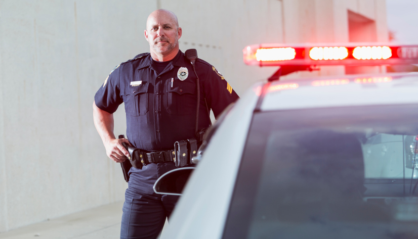 Police Office standing next to Patrol Car