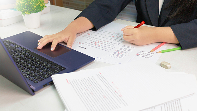 Person at desk editing papers.