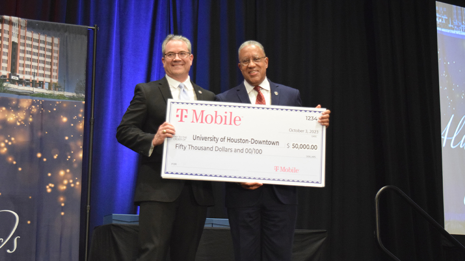 Vice President Javier Zambrano & President Loren J. Blanchard holding a $50,000 check from T-Mobile