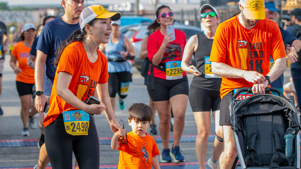Participants of the Saint Arnold's 5k/10k. A mother, father and child running.