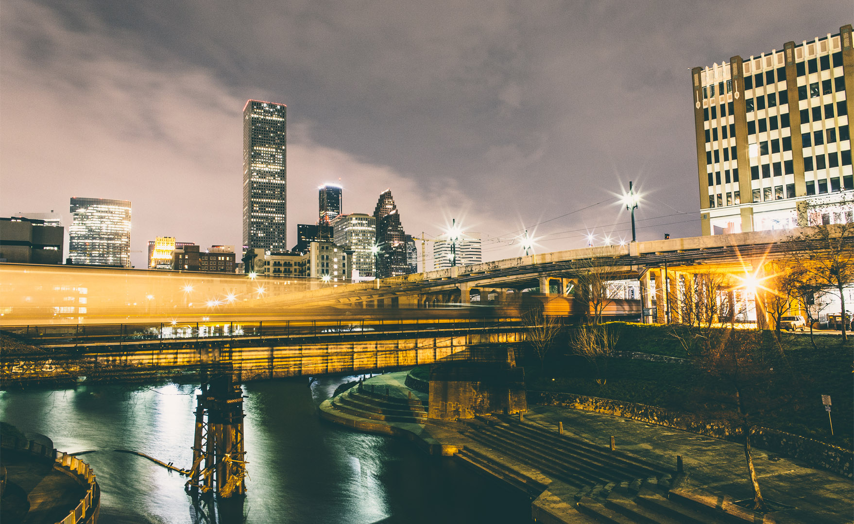UHD main building, Buffalo Bayou and downtown Houston buildings at night