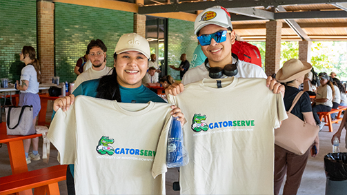 Two university of houston-downtown students at a "Gatorserve" volunteer event.