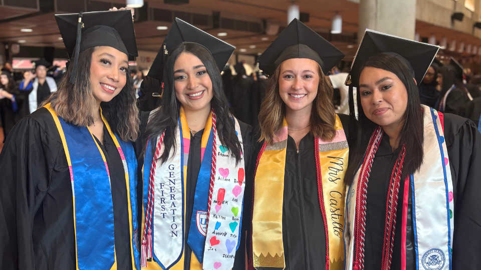 Student posing with friends in their gap and gown
