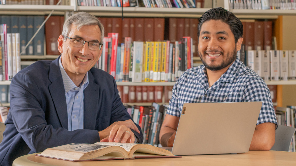 Faculty meets with student in the library