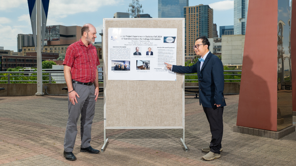 Two men standing in front of a board doing a presentation