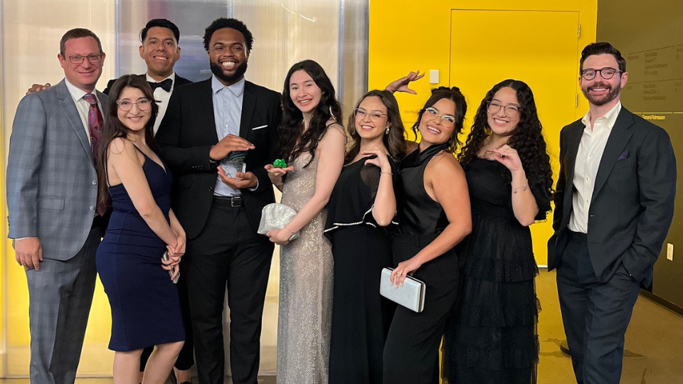 Group of winners holding award and posing for picture