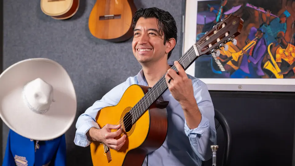 Mariachi performer David Moreno holding a guitar