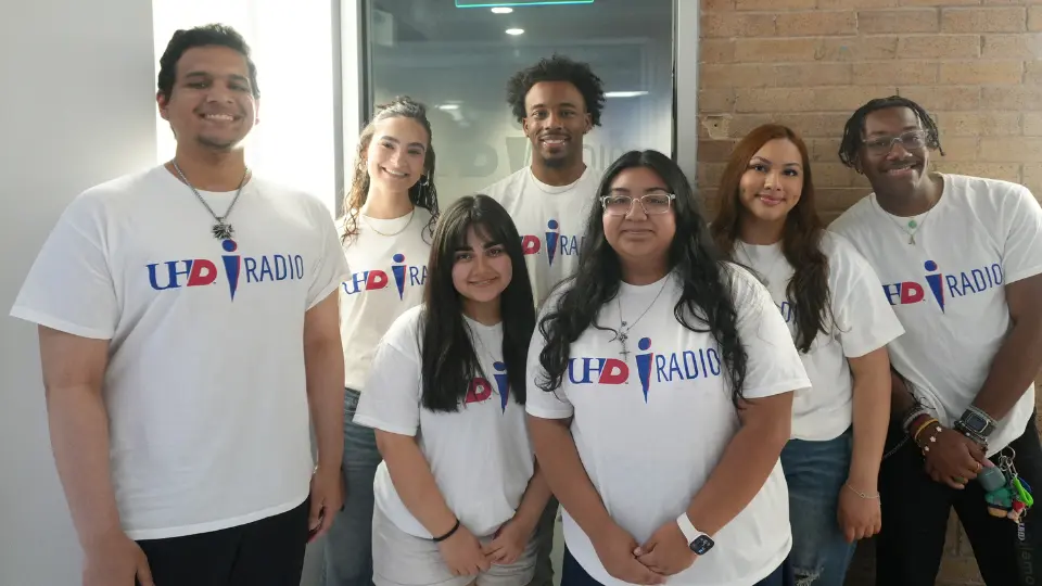 Seven iRadio DJs gathered together wearing white shirts