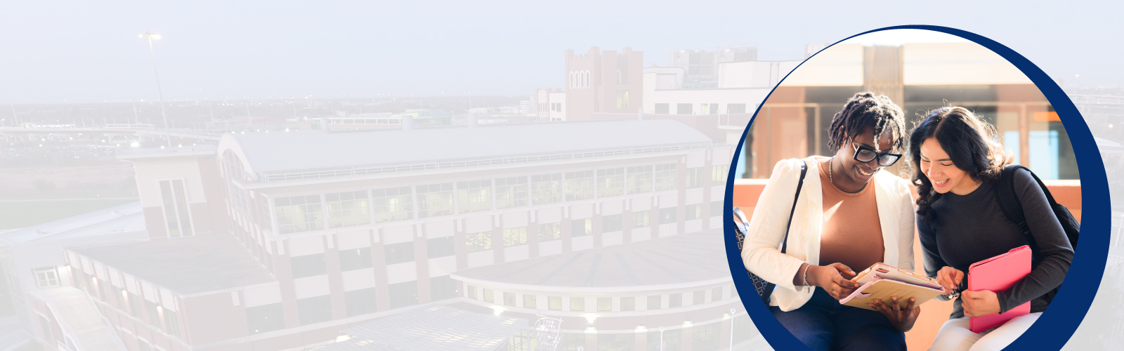 Two female students looking at class notes together