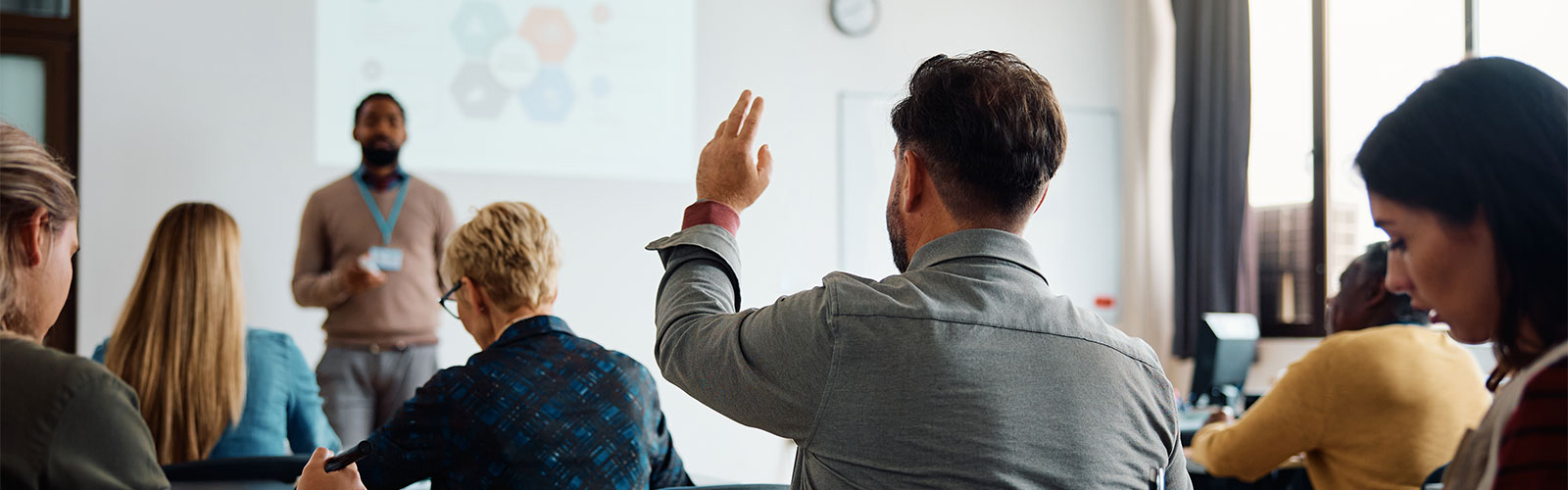 Person raising hand in a classroom