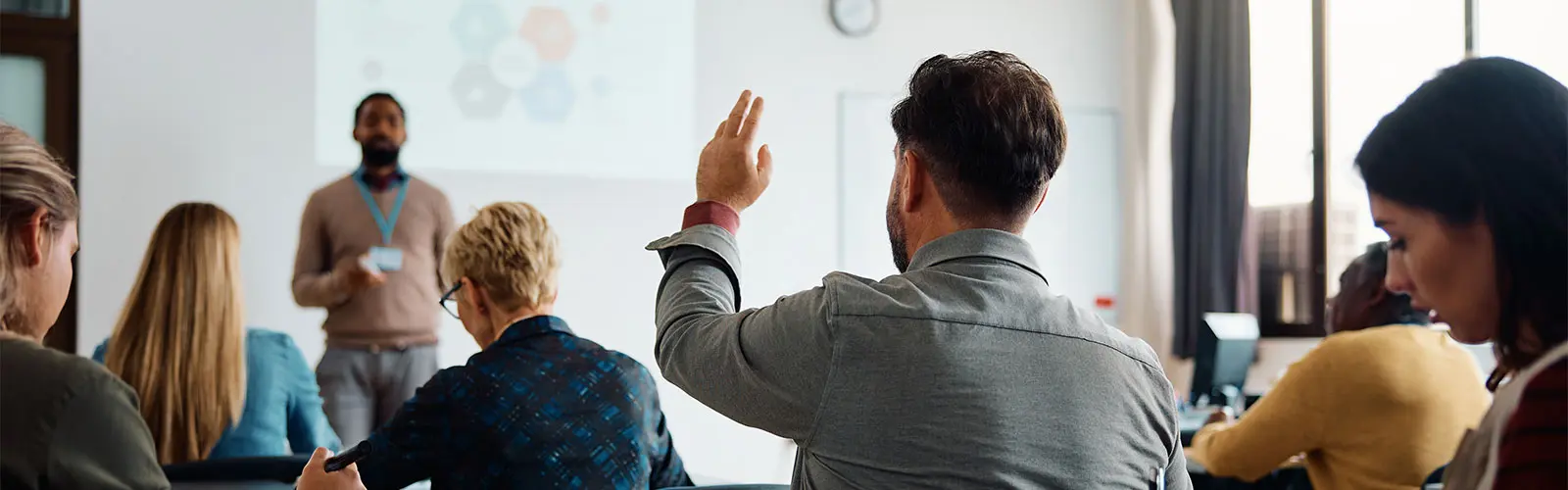 Person raising hand in a classroom