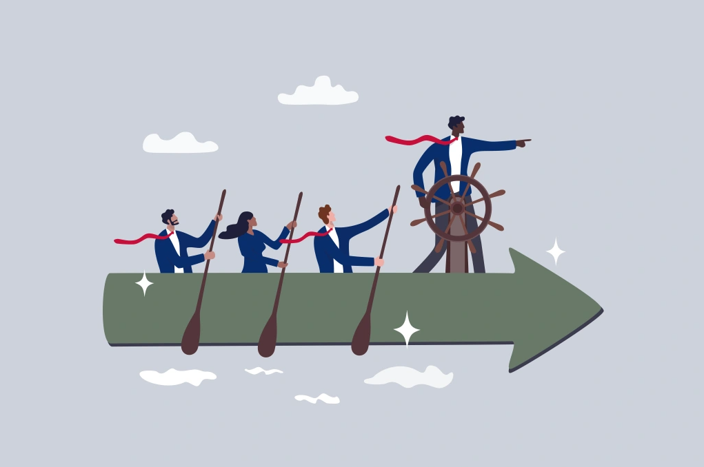 A leader standing in front of a ship steering wheel steers a team of people forward.