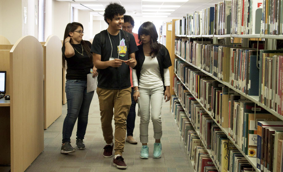 students walking in the library stacks