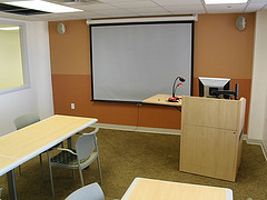 A study room with a projector, podium, and working area