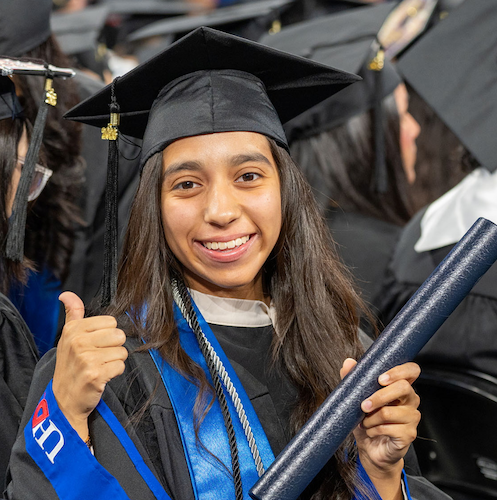 Graduating student smiling at UHD's 80th commencement