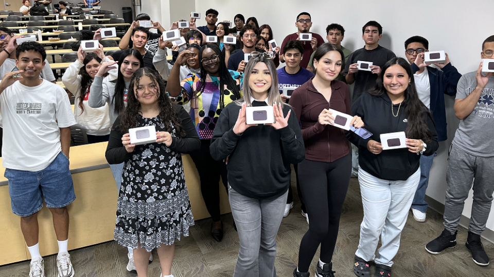 UHD Freshman pose with T-Mobile Wi-Fi Hotspot units