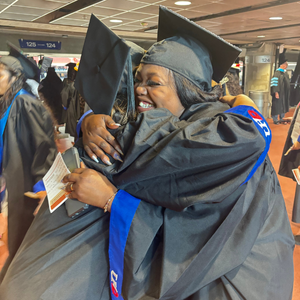 two uhd students hug at uhd's 78th commencement ceremony at NRG