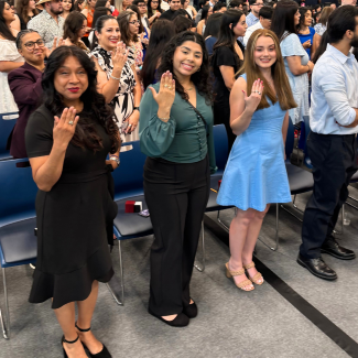 Three students hold up their UHD rings.
