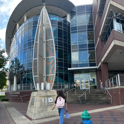 A student walking toward the entrance to UHD's College of Public Service.