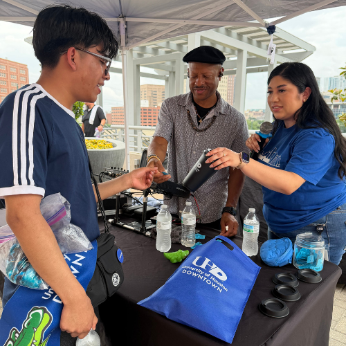 Two staff members in Enrollment Management assist a high school senior and future university of houston-downtown student at the university's commitment day in april 2026 in downtown Houston
