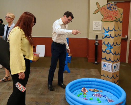 Shikyna William watches at College of Humanities and Social Sciences Assistant Dean plays a fishing game at the qep pep rally.