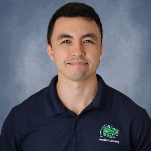 Jacob Fox, Acadmic Advisor at the College of Public Service, smiles in a collared shirt with the words "academic advisor" on it