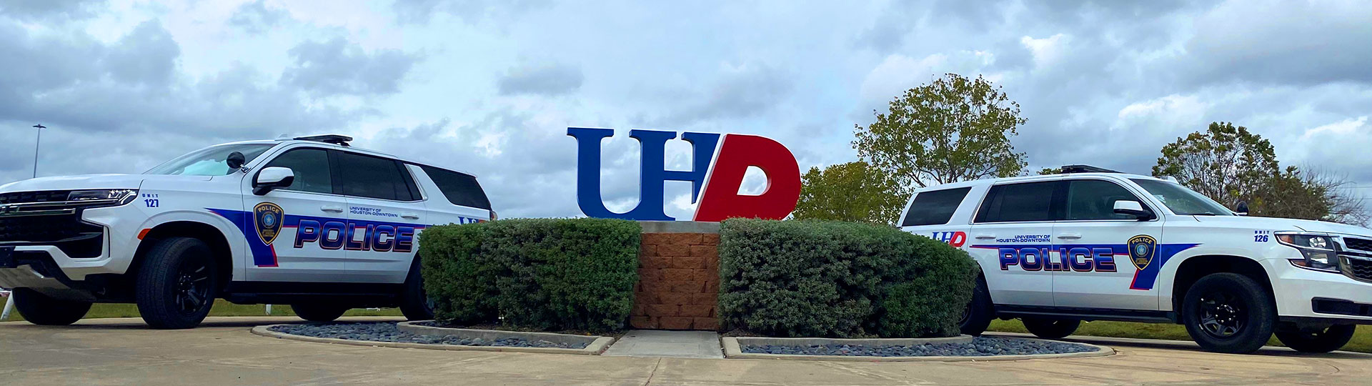 Two Police cars flanking a UHD sign