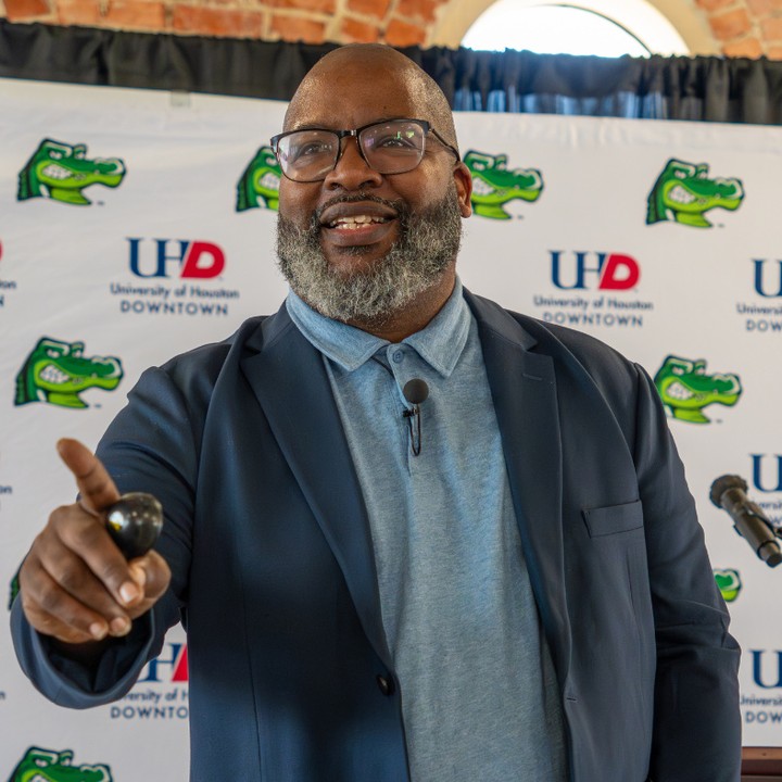 Brian E Francis speaking in front of UHD logos