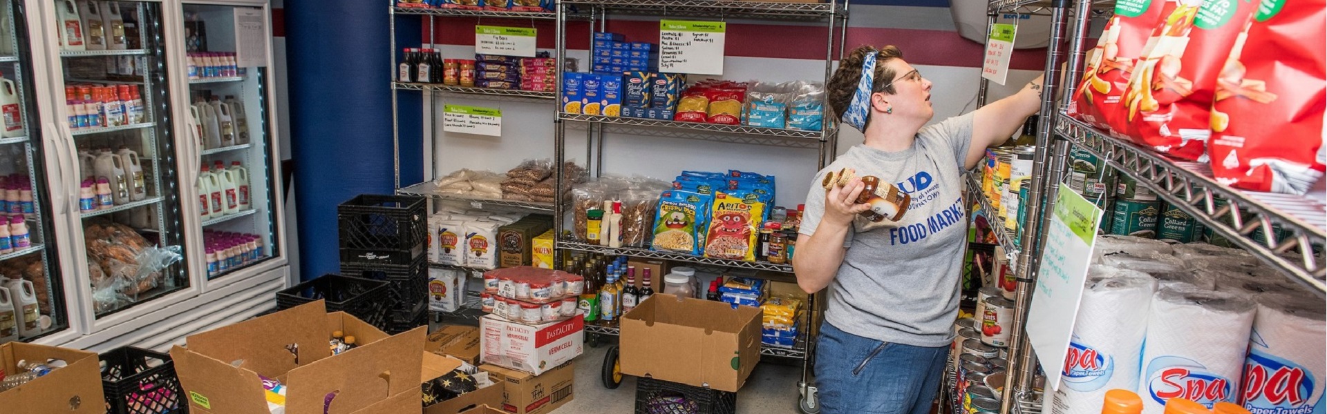 UHD student organizing food at the Food Market