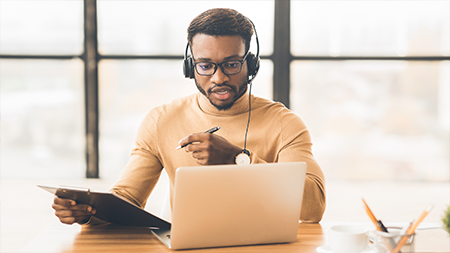 Student wearing headphones during meeting on laptop