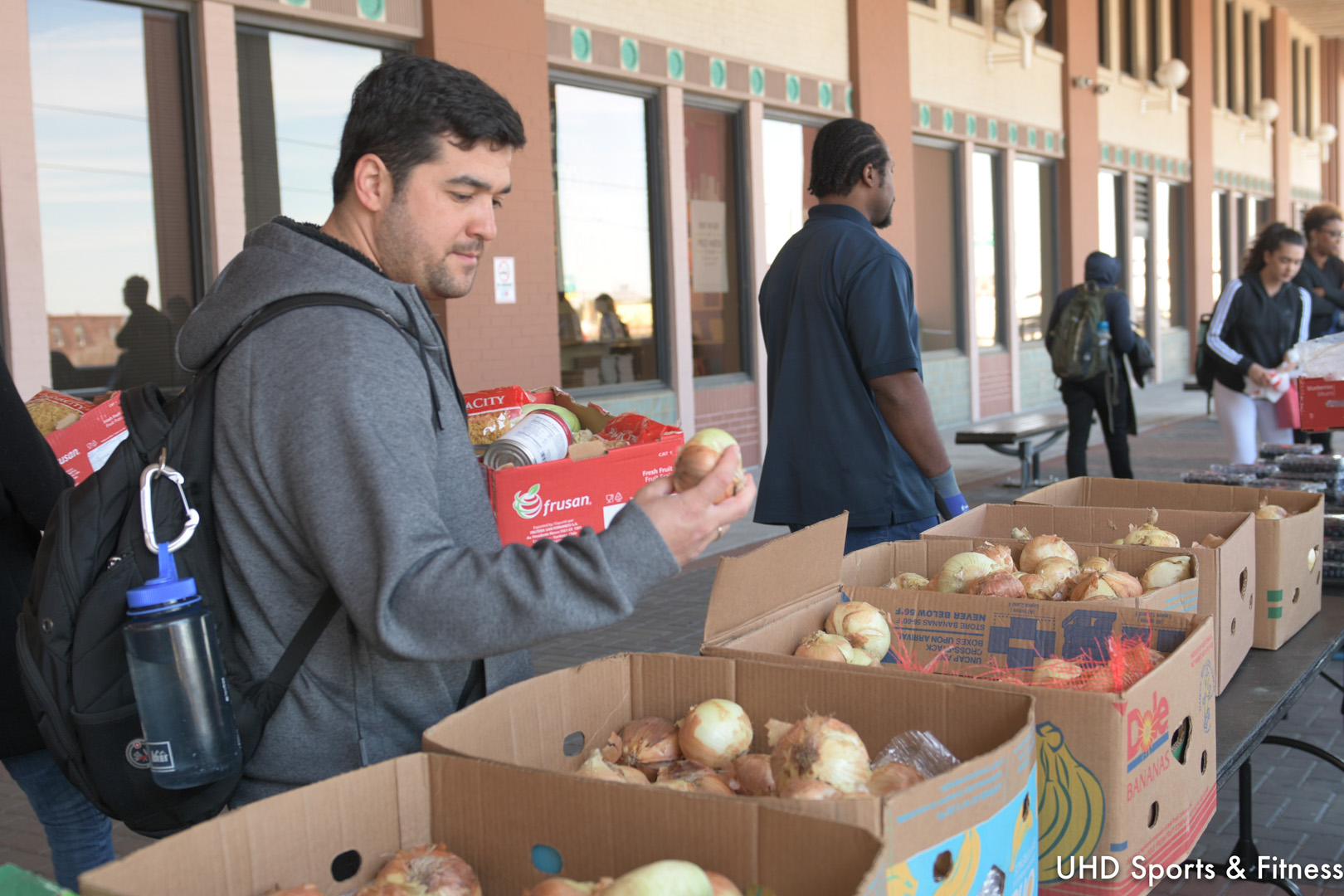 Student inspecting an onion at a food distribution event.
