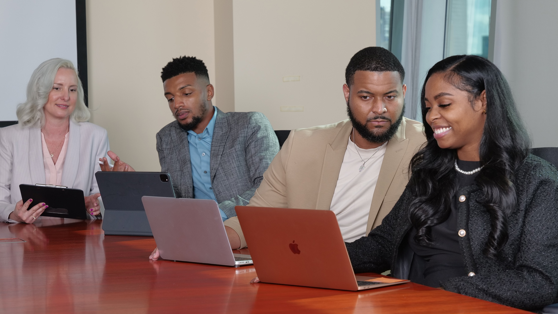 UHD professionals on laptops at a conference table