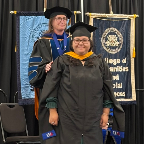 Diana Ambrosio smiles while being formally hooded at the uhd graduate student hooding ceremony