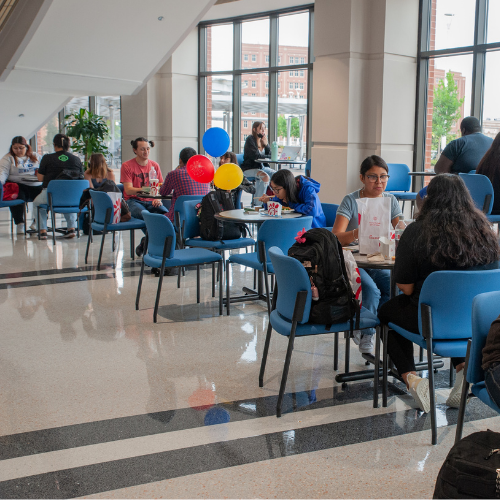 University of Houston Downtown students sit at tables and eat lunch in the Skyline Lounge 
